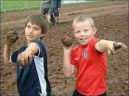 photo of two kids throwing mud
